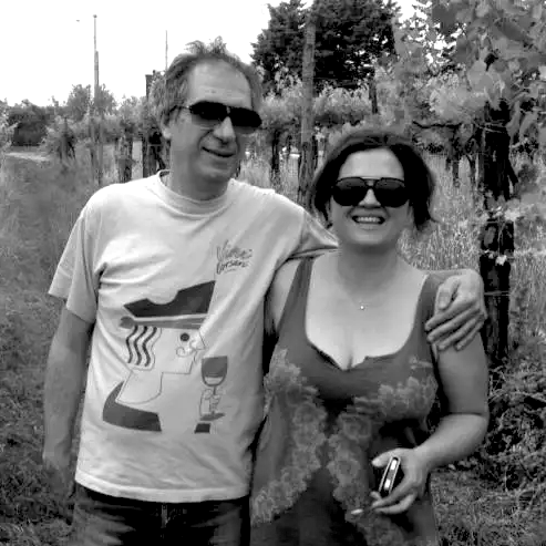 Two people standing in a vineyard with sunglasses on, black and white photo.